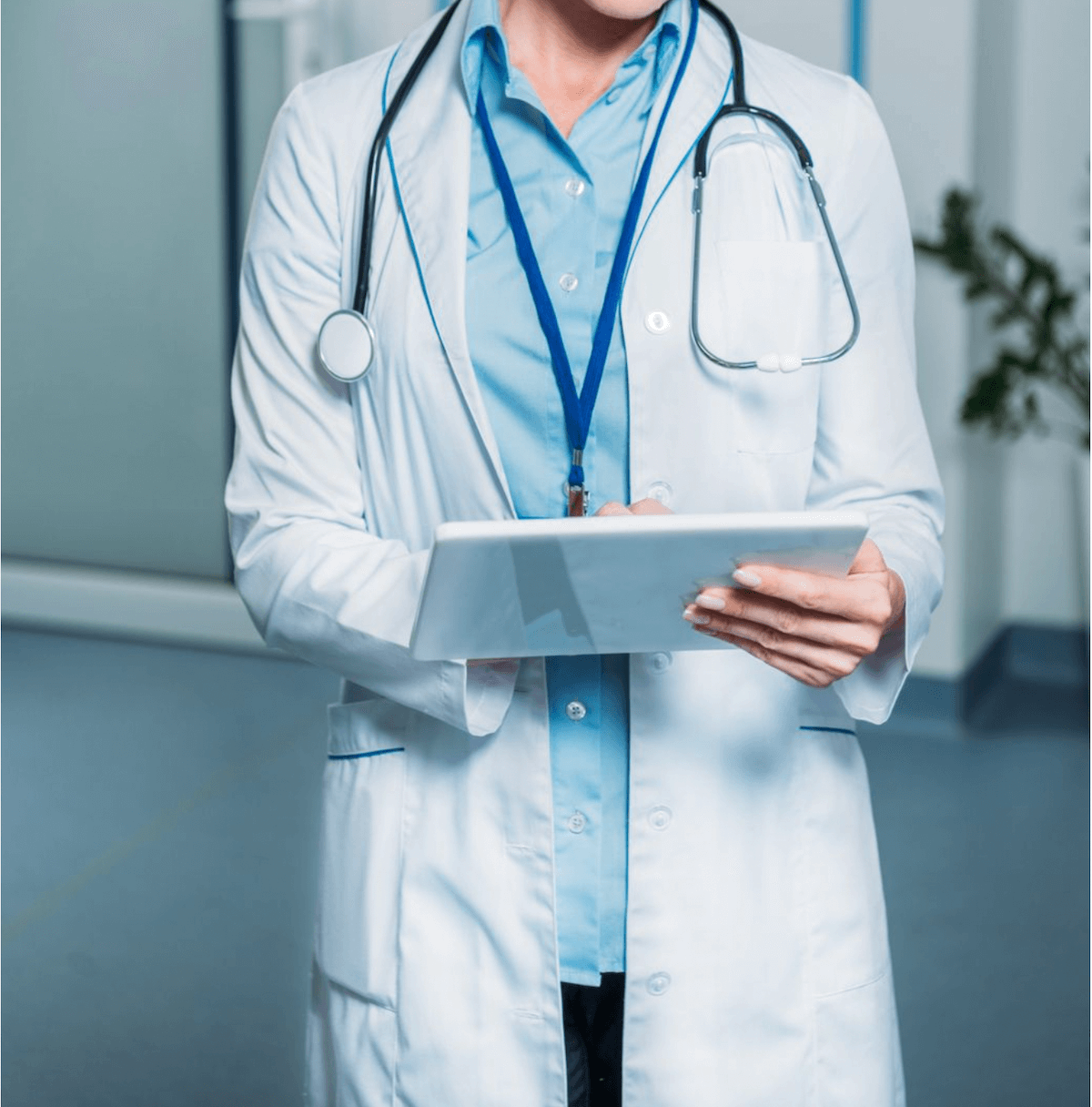 Female doctor in white lab coat with stethoscope and tablet illustrating surgical options for pelvic floor prolapse.