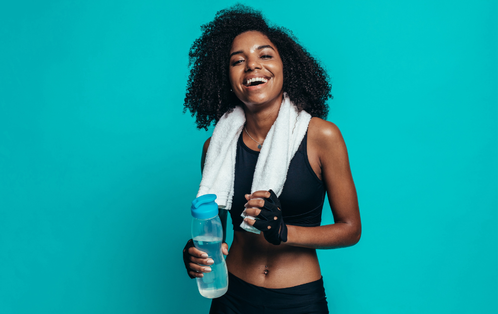 Young woman exercising with water bottle and towel.