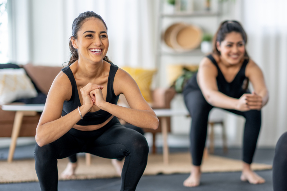 Two young women doing squats as exercise for pelvic health. 