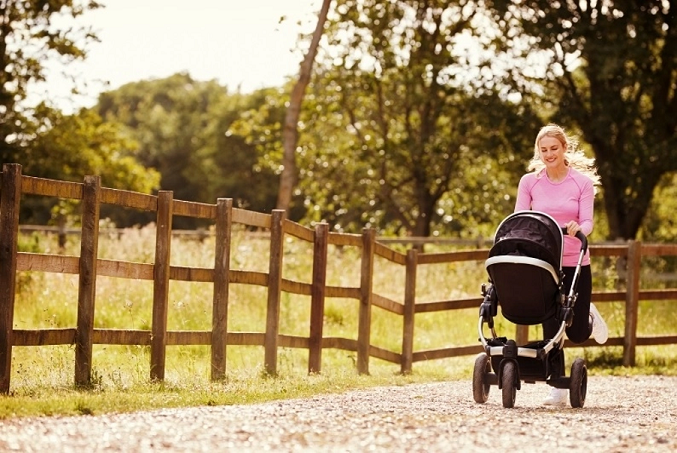 Young blonde woman running while pushing a baby in a pram shows that different types of exercise after birth will suit different women.