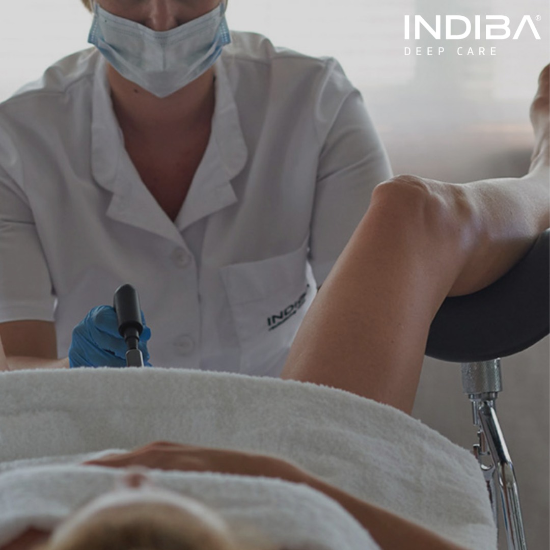 A woman having INDIBA Activ electromagnetic therapy to treat painful sex caused by vulvovaginal atrophy and vaginal dryness.